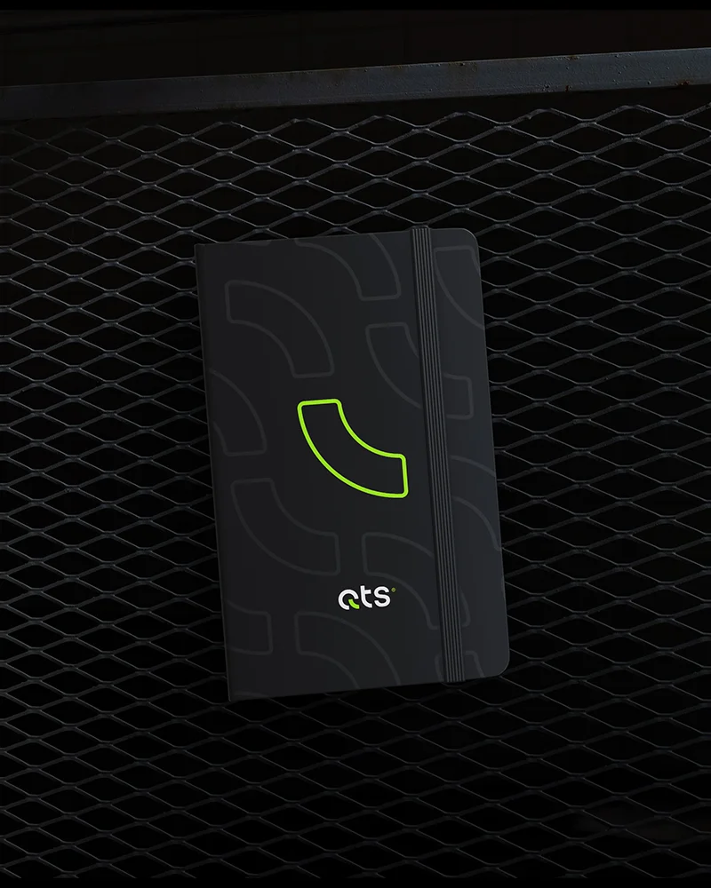 QTS branded black notebook design featuring custom neon green emblem and pattern layouts